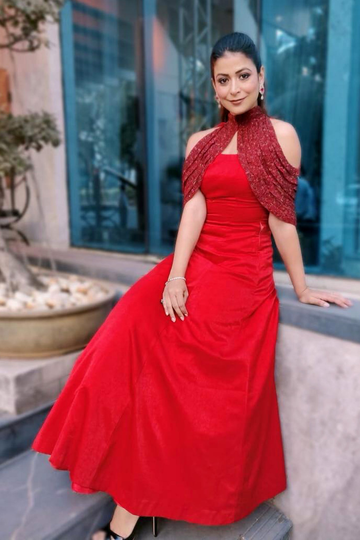 Freshia in Modo Caldo red fit-and-flare gown with padded bodice, straight neckline, hand-embroidered embellishments, and dramatic cape collar for evening and festive wear