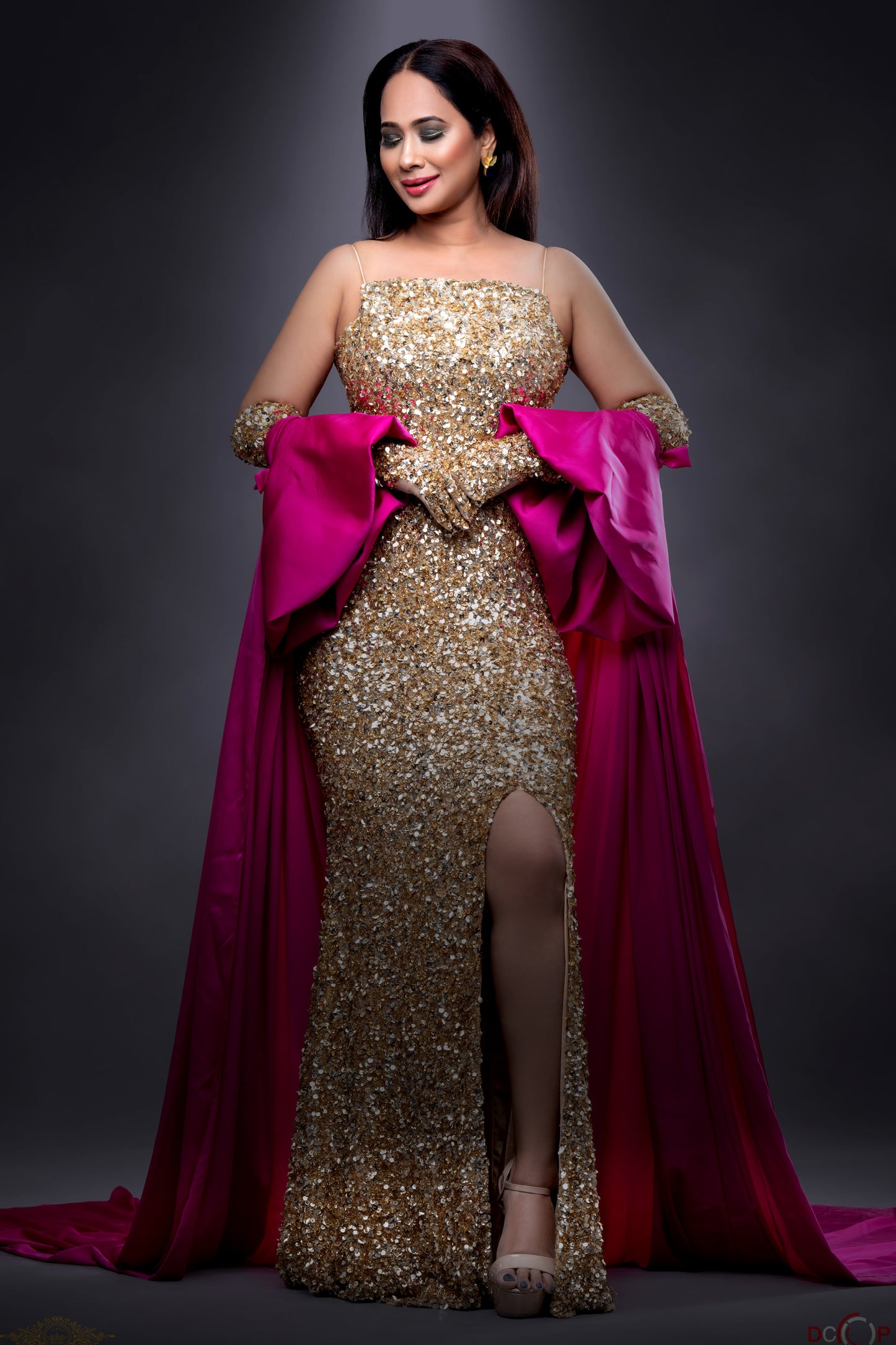 Archana Chowdhry in Modo Caldo golden hand-embroidered embellished slip gown with broad neckline, thigh-high slit, spaghetti straps and fuchsia pink tulle trail and gloves for Mrs. Universe Pageant