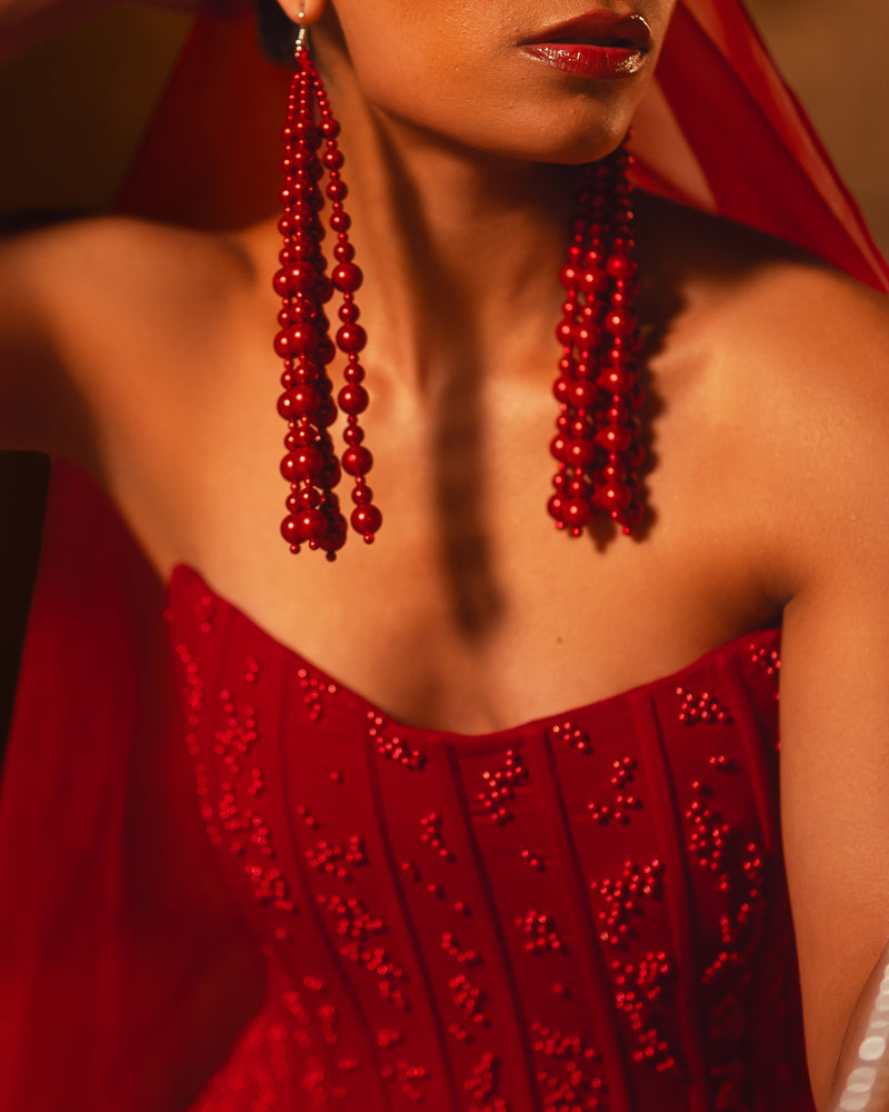 ISHQe campaign: close-up of a red beaded corset bodice and red bead tassel earrings