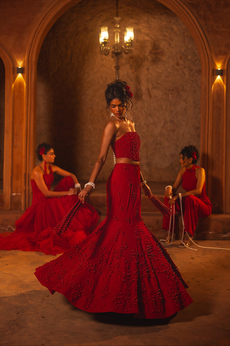 ISHQe campaign: red corset mermaid lehenga swirling, two models in red seated at either side