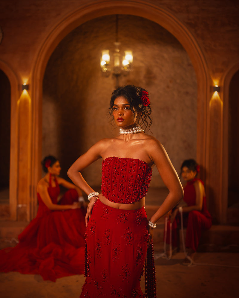 ISHQe campaign: red strapless corset top and skirt, two models in red seated behind