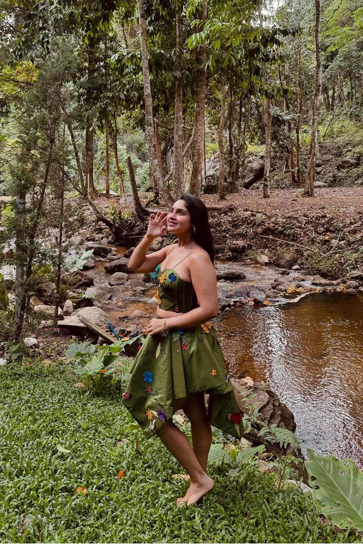 Pavitra Kaur in Modo Caldo green fit-and-flare corset top with asymmetric skirt and fringed cape, featuring signature applique embroidery for festive and formal wear