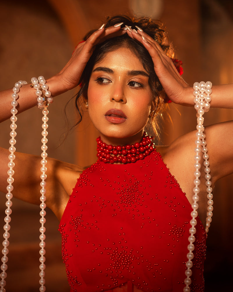 ISHQe campaign: close-up of a red halter neck top with a red beaded choker and pearl strands