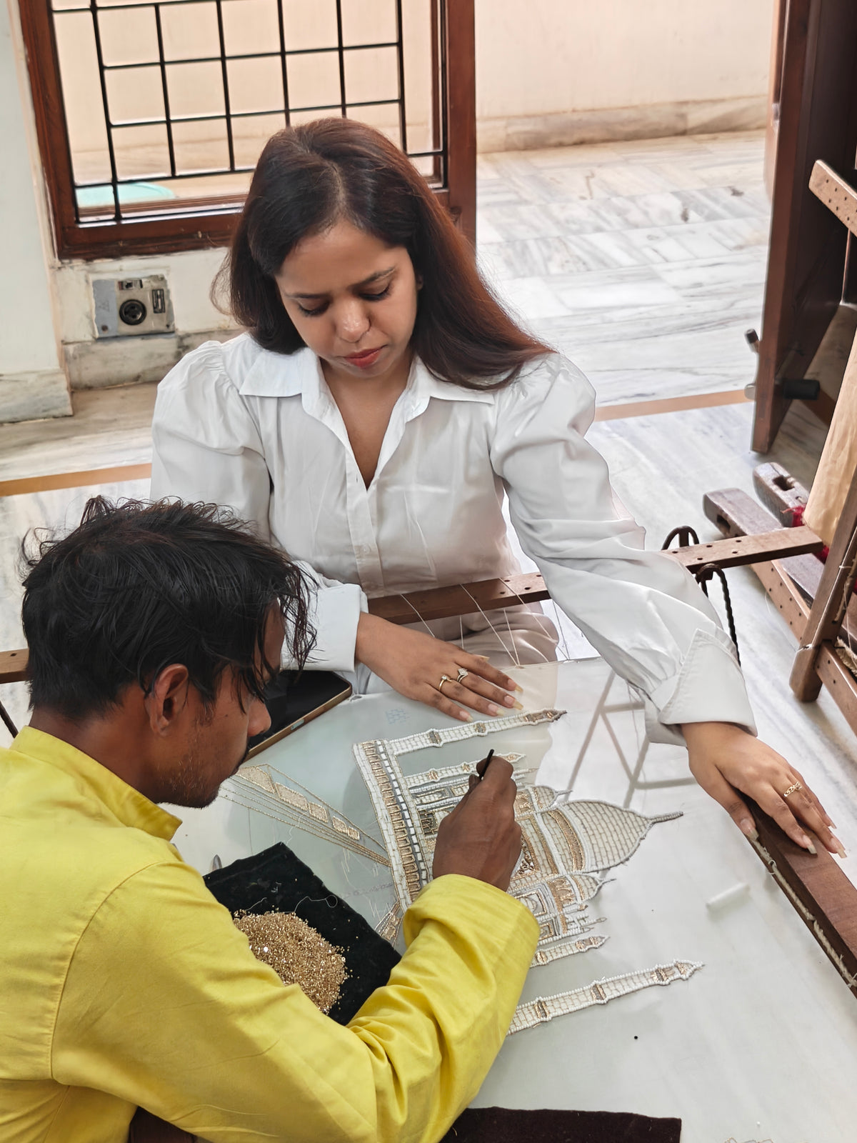 Jigyasa Jolly guiding an artisan at the embroidery table while making the Cannes gown