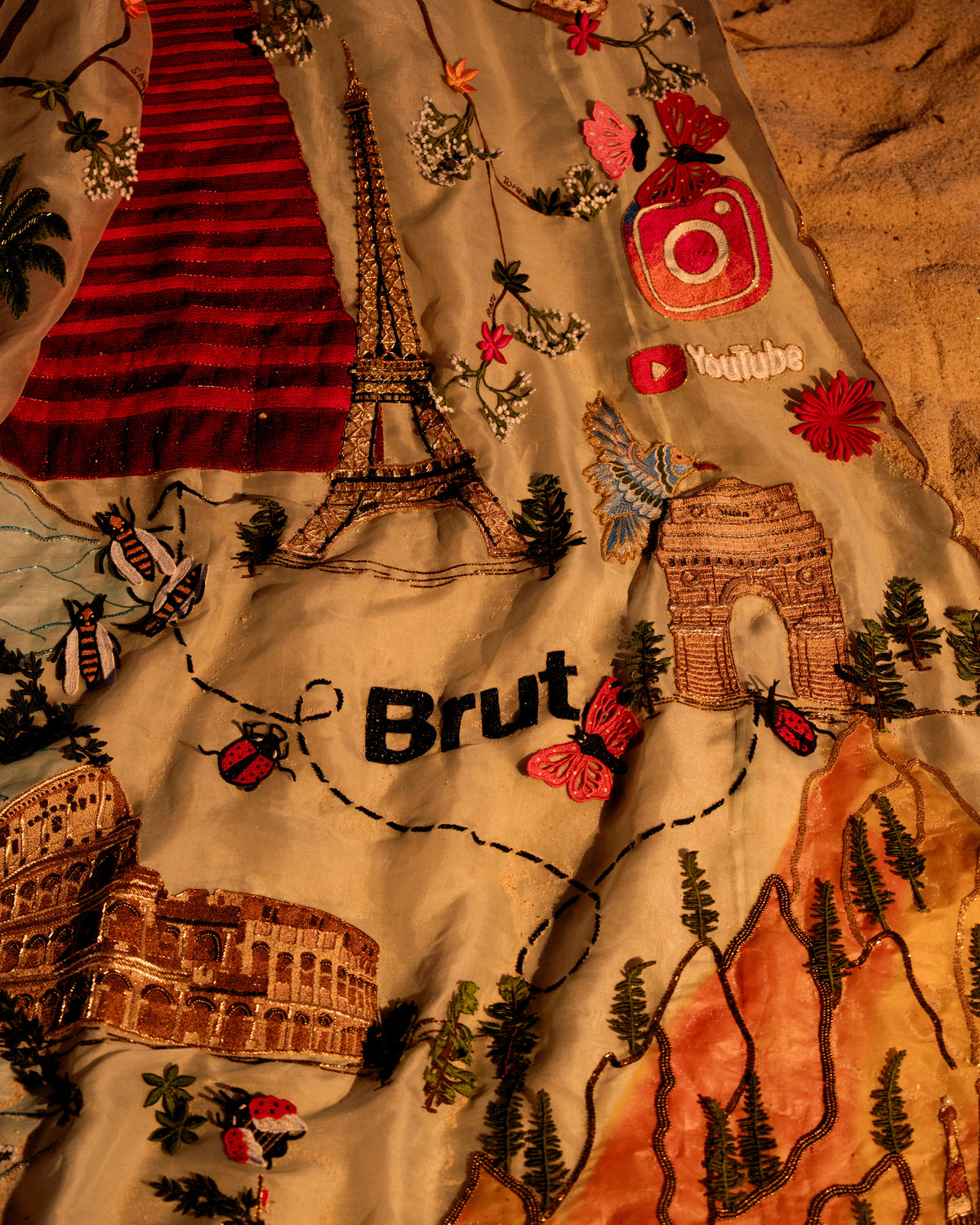 Embroidery detail on Natkhat Zindagi: Eiffel Tower, Colosseum, the Brut logo and India's landmarks