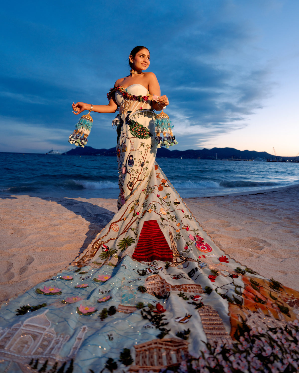 Full length Natkhat Zindagi gown spreading its embroidered train across the sand at Cannes