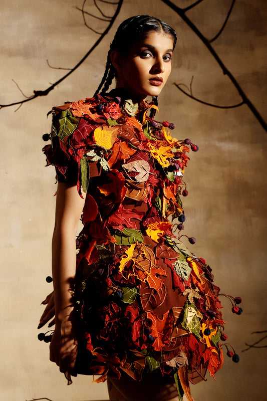 Leaf covered dress with sculpted shoulders, hem standing away from the body