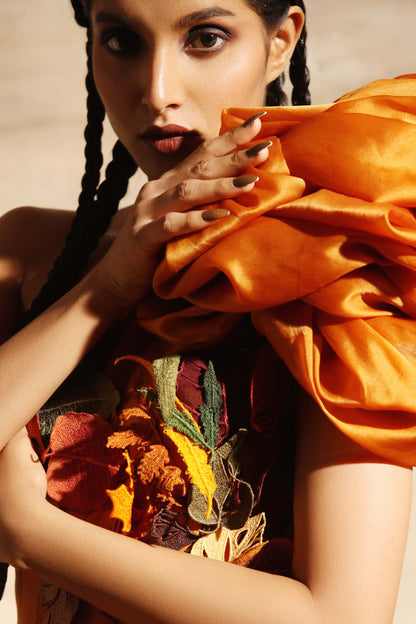 Appliqued leaves in autumn colors across the bodice of the amber dress