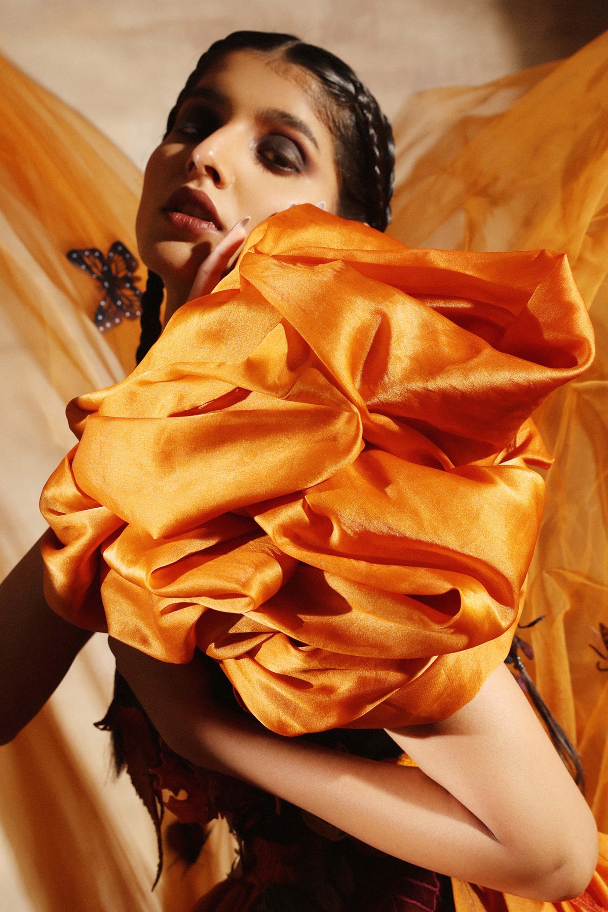 Folded organza forming the shoulder of the amber dress, seen close