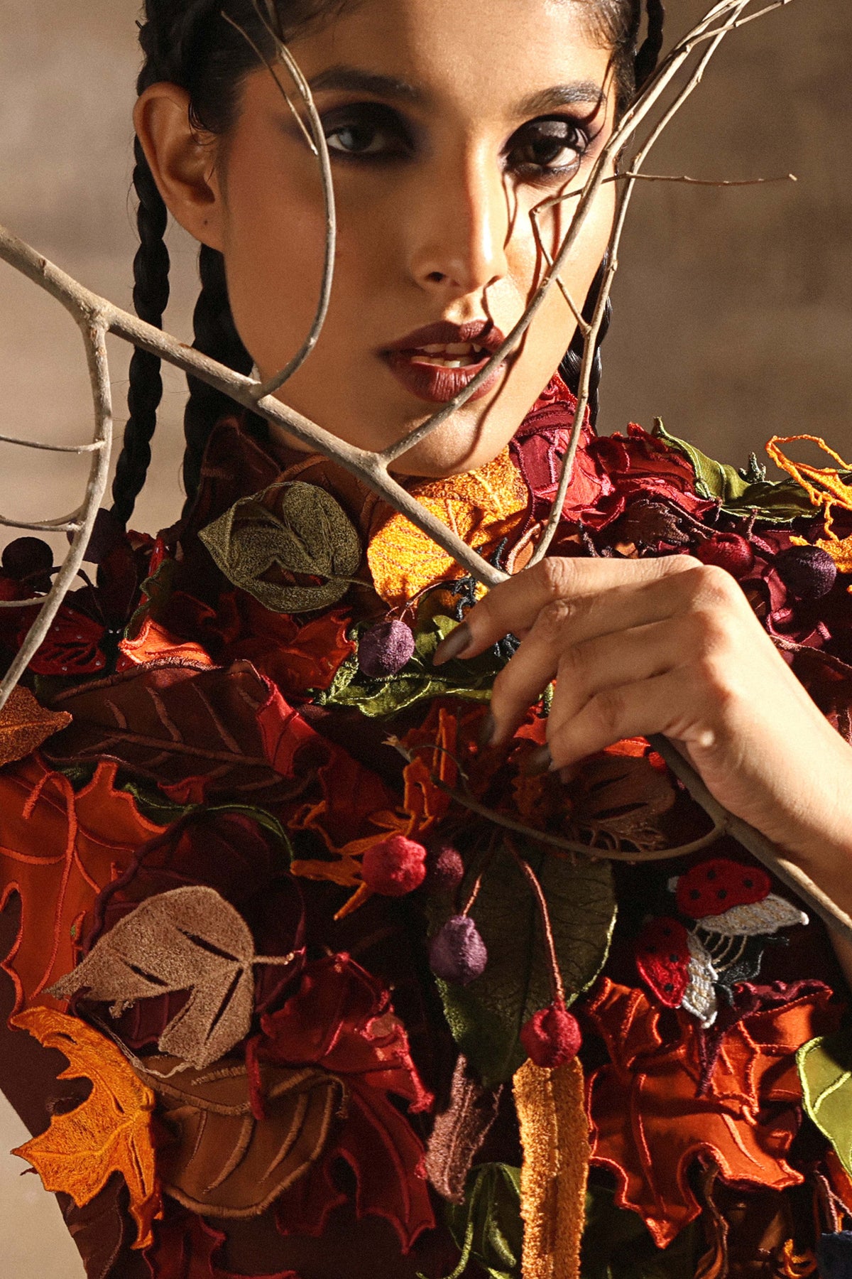 Berries and stitched foliage massed over the shoulder of the art dress
